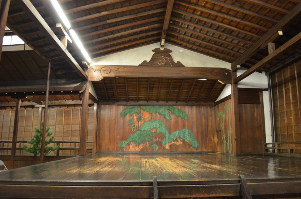 An old wooden noh stage with light patches on the surface where the varnish has been worn thin