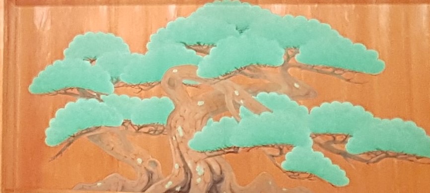 A large painted pine tree that stretches across the entirely of a wooden panel.