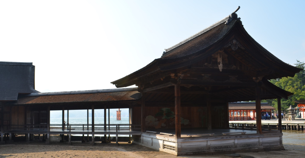 An old noh stage on a sandy beach at low tide.