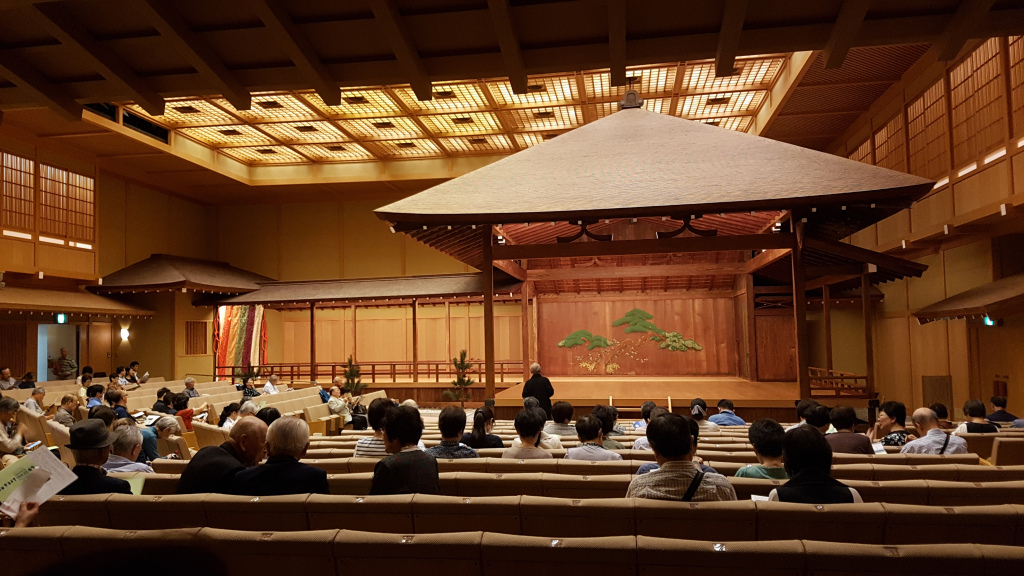 Wooden nogaku stage with theatre style seating to the front and the side of the stage