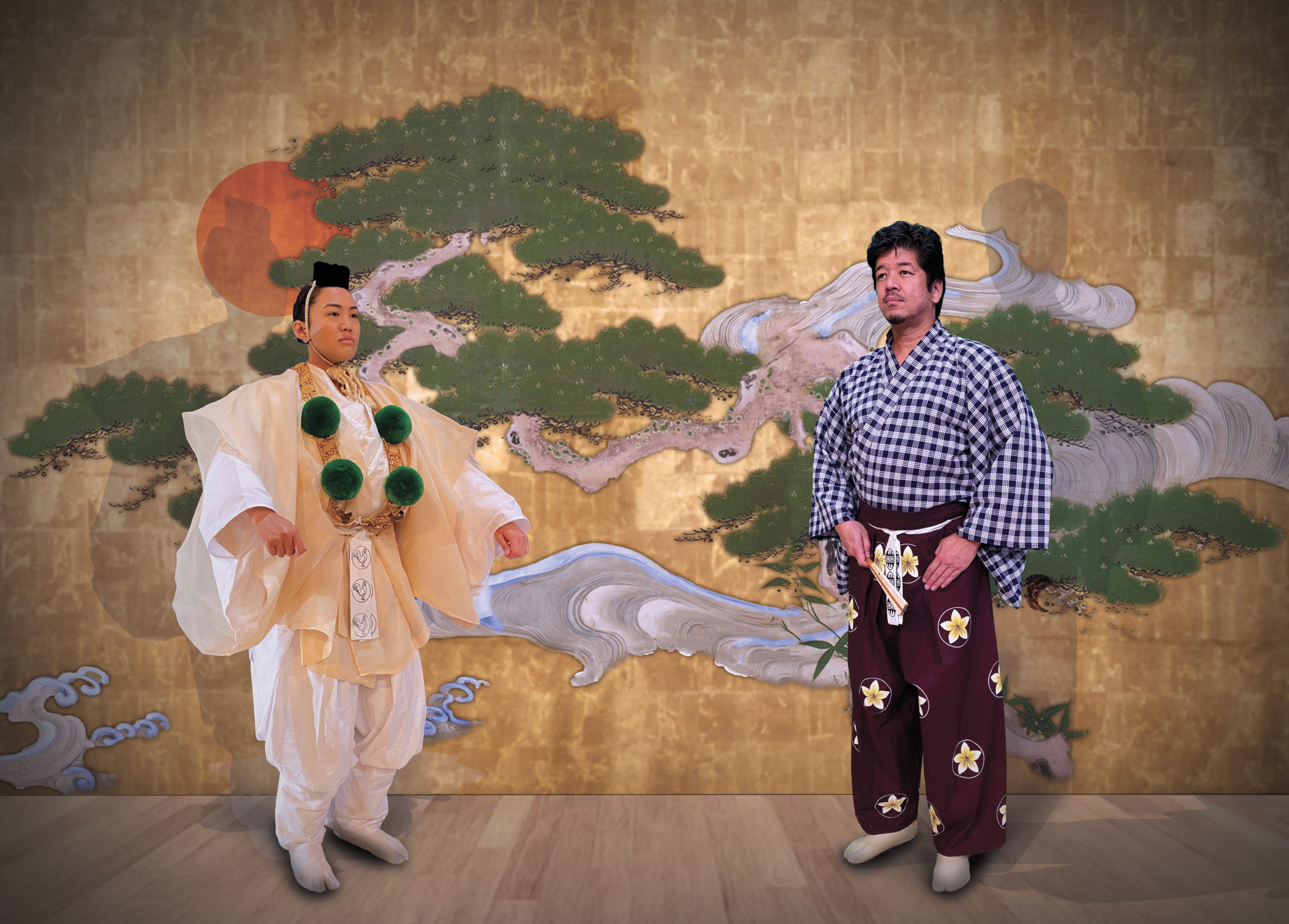 An actor in white yamabushi regalia with green pompoms and an actor with a blue palaka kimono top and plumeria patterned purple hakama stand in front of a pine tree backdrop on a wooden floor