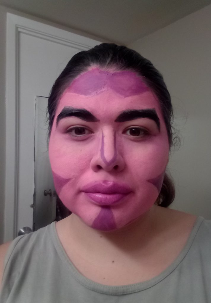 A woman with pink face paint accented at the edges with purple marks